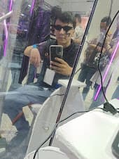 Me reflected in the mirror of one of the interactive AI installations we built for the event, under purple lighting.